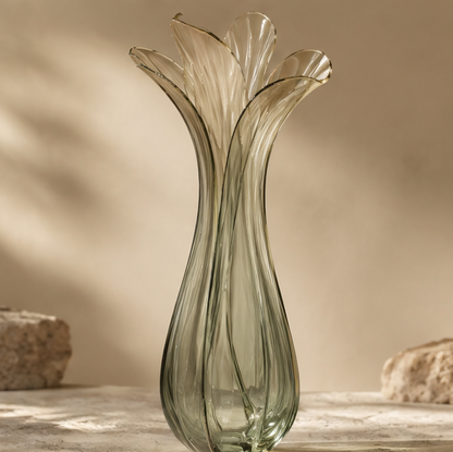 FORMIQI olive green multi-petal tulip-form ribbed art glass vase on stone surface with rock backdrop, clean background