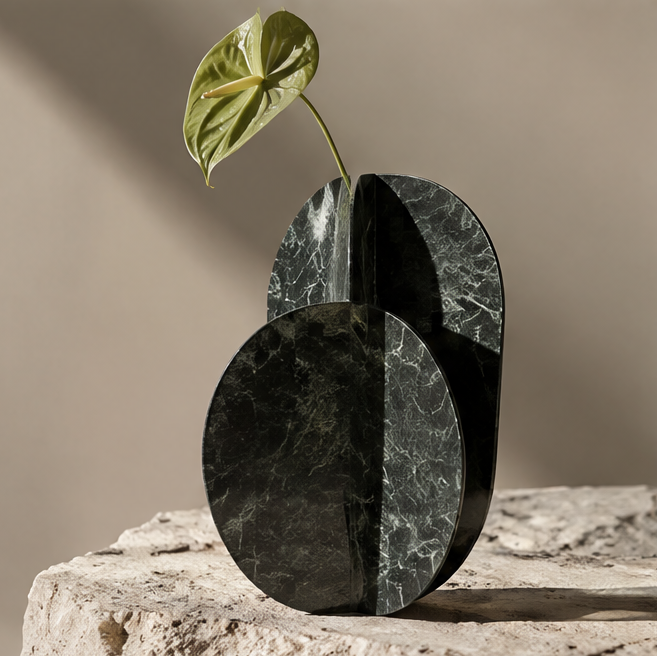 FORMIQI forest green marble dual-disc geometric vase with anthurium leaf on stone surface, clean background